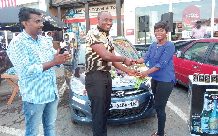  Mr Derick Kobena Bonney (middle) presenting the keys to the Hyundai i10 to Ms Ohemaah Akyea 